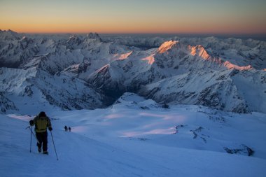 Alpinists on their way to the Elbrus in daybreak time. clipart