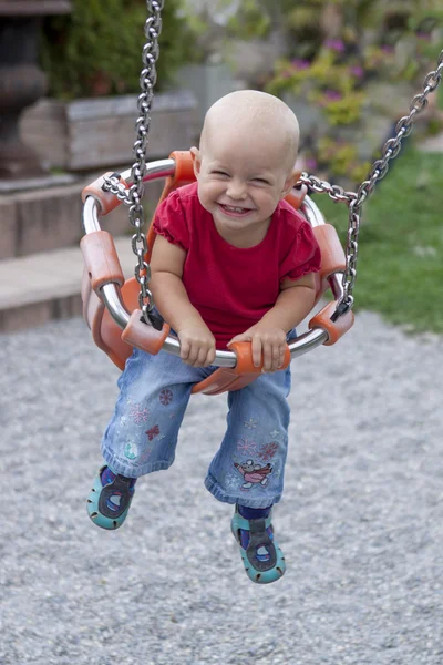 Mutlu, gülümseyen bir bebek sallanıyor