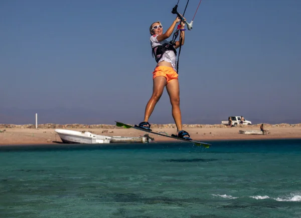 Mutlu uçurtma sörfçü kadın atlama