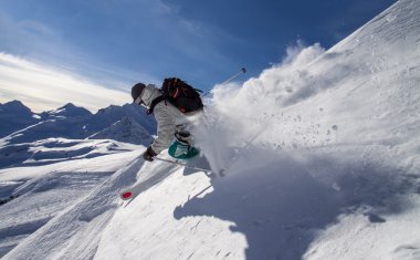 Kayakçı yüksek dağlarda... Freeride güneşli günde taze toz karda