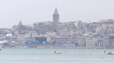 Arka planda Galata kulesi, denizden geçen gemiler.