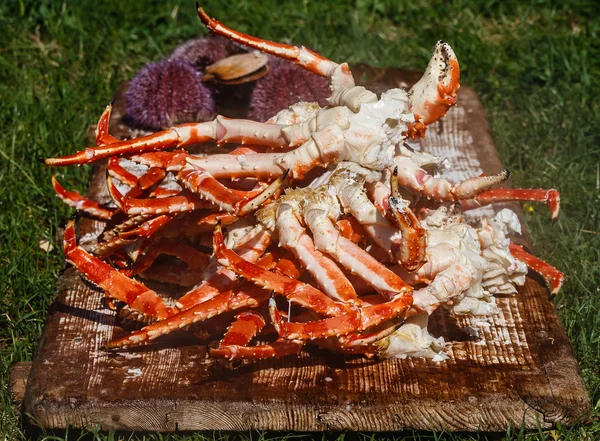 legs of a red king crab with raw sea urchins and  scallops