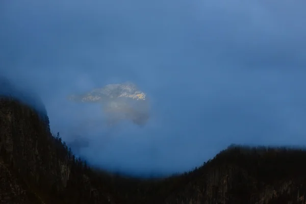 एक उभरते सूरज की किरणों से प्रकाशित पर्वत शिखर — स्टॉक फ़ोटो, इमेज