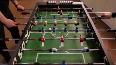 Arkadaşlar birlikte langırt oynarken eğleniyorlar. Teneffüste masa futbolu oynayan meslektaşlar. Masa futbolunu seven insanlar. Masa futbolu vurucu oyununu kapat