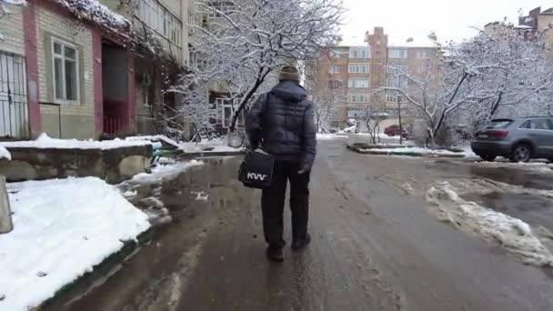 St. Petersburg, Russia 10.01.2021 An elderly disabled man walks along a slippery street in winter and limps on his leg — 图库视频影像