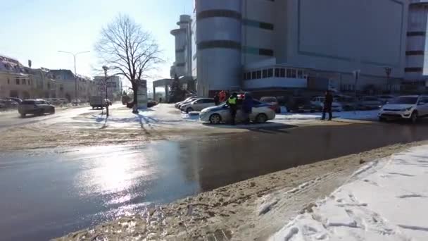 Минеральные воды, Ставропольский край, Россия 01.15.2021 Сотрудник ГИБДД стоит у стандартного автомобиля с правонарушителями — стоковое видео