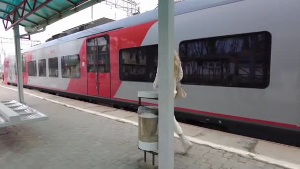 Essentuki, Rusia. 02.13.2021 Estación de tren de Piron, donde una joven camina junto al tren que sale — Vídeos de Stock