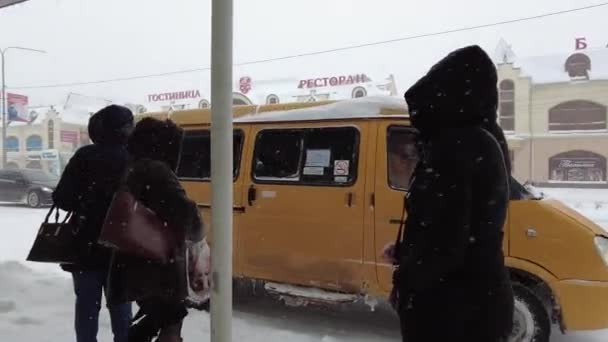 Mineralnye Vody, Russland. 03.12.2021. Passagiere stehen im Schneesturm an einer Bushaltestelle und warten auf ihren Bus im Winter — Stockvideo