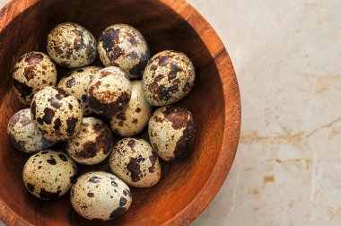 Quail eggs in a plate on a marble background. The view from the 