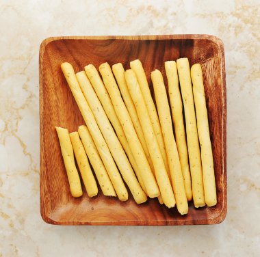 Ekmek mermer bir arka plan üzerinde ahşap bir kase içinde sopalarla. üst görünüm