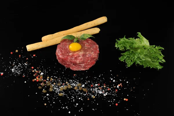 Steak Tartar. Carne molida y huevo crudo con hierbas y especias en un — Foto de Stock