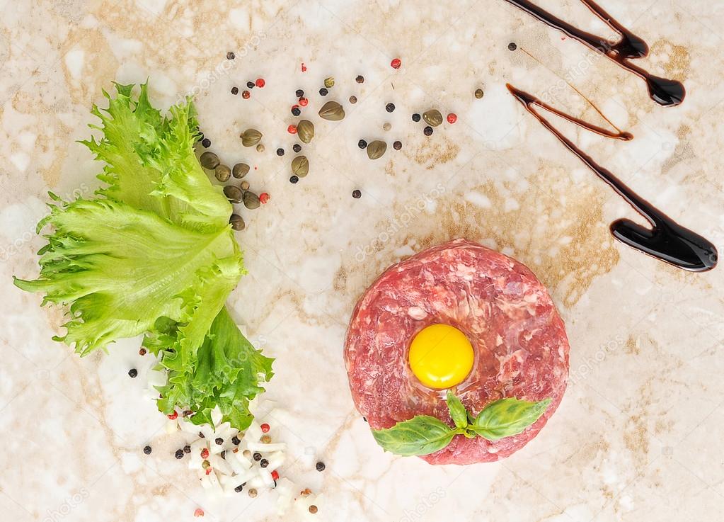 Steak Tartar. Ground beef and raw egg with herbs and spices on a Stock
