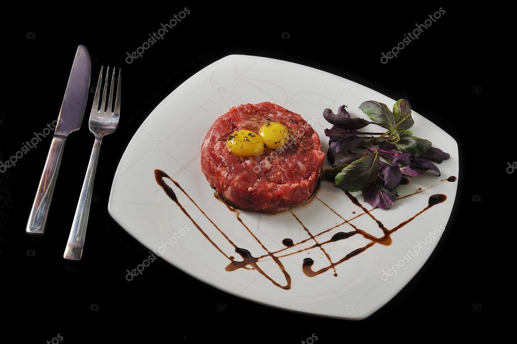 Steak Tartar. Ground beef and raw egg with herbs and spices on a
