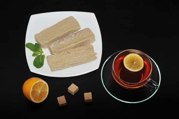 Халва на белой тарелке - восточные сладости. чай в прозрачном m — стоковое фото