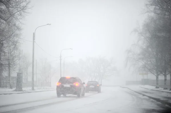 Сильный снегопад. авто по заснеженной дороге — стоковое фото