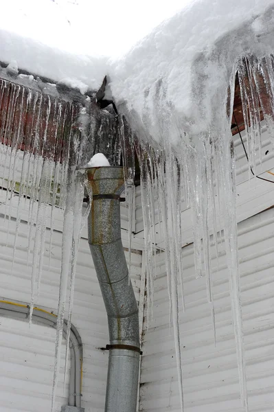 Ijspegels op het dak en de downpipe — Stockfoto