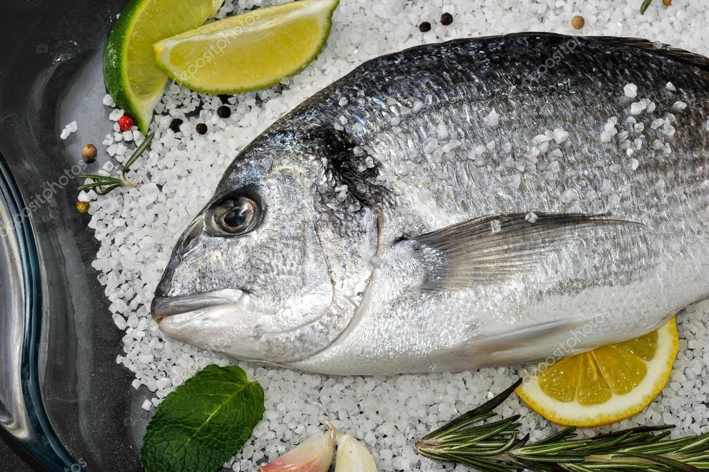 Pesci Di Dorado Sono In Piatto Di Vetro Con Sale Rosmarino Aglio