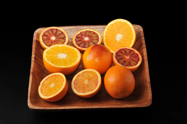 Oranges whole and cut in half on a wood tray. background from us — Stock Photo, Image