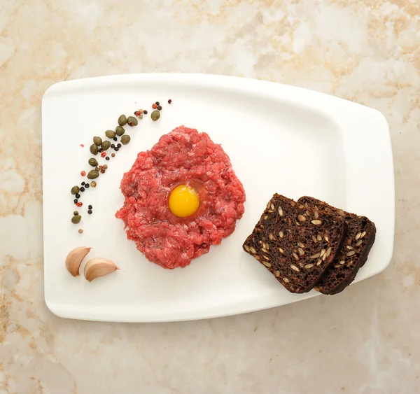 Carne picada con huevo crudo en una bandeja de cartón blanco — Foto de Stock