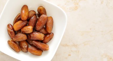 Kurutulmuş tarihleri meyve mermer bir zemin üzerine bir kase