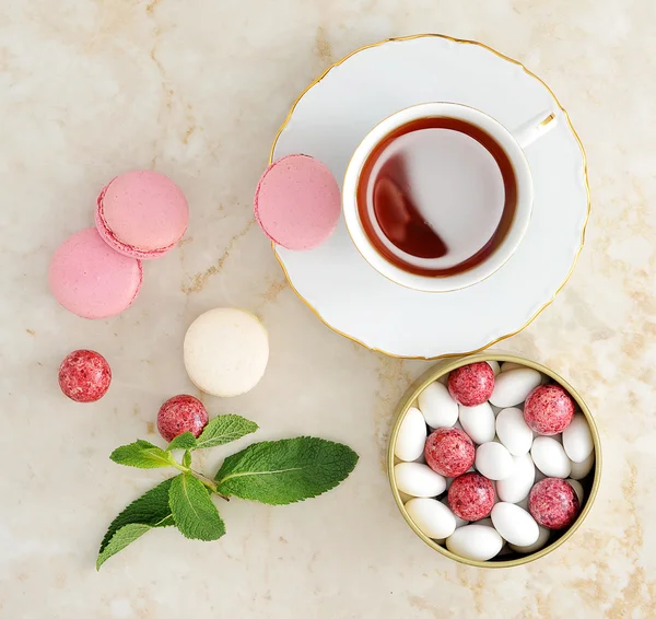 Macaron colorido com uma xícara de chá — Fotografia de Stock