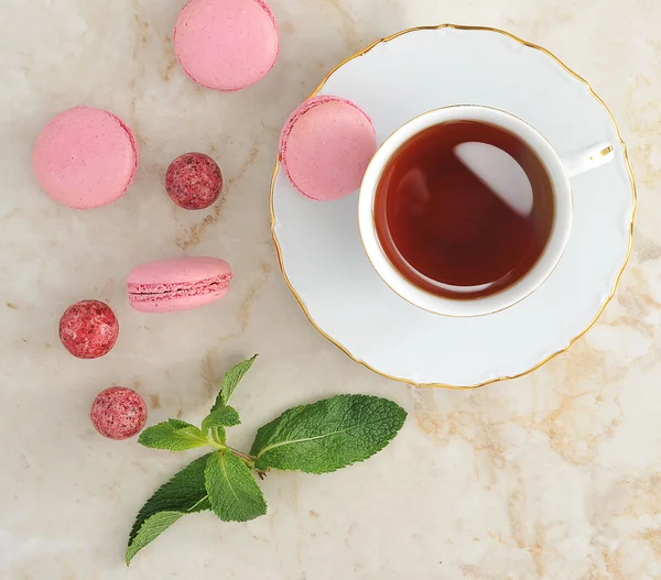Macaron colorido com uma xícara de chá — Fotografia de Stock