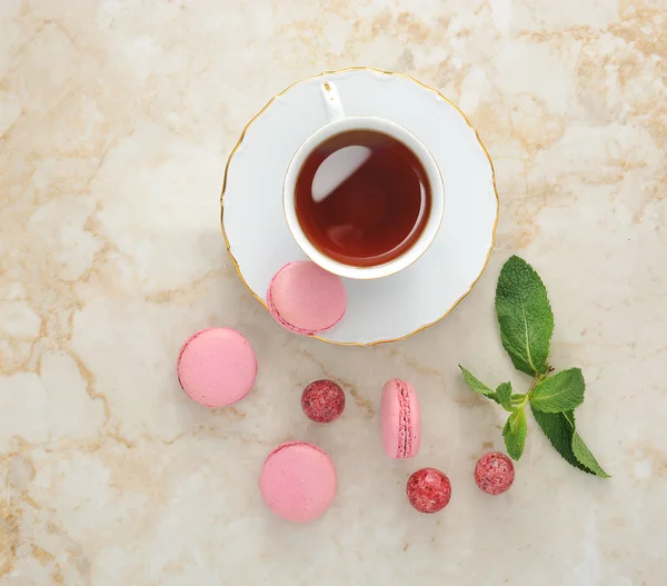 Macaron colorido com uma xícara de chá — Fotografia de Stock