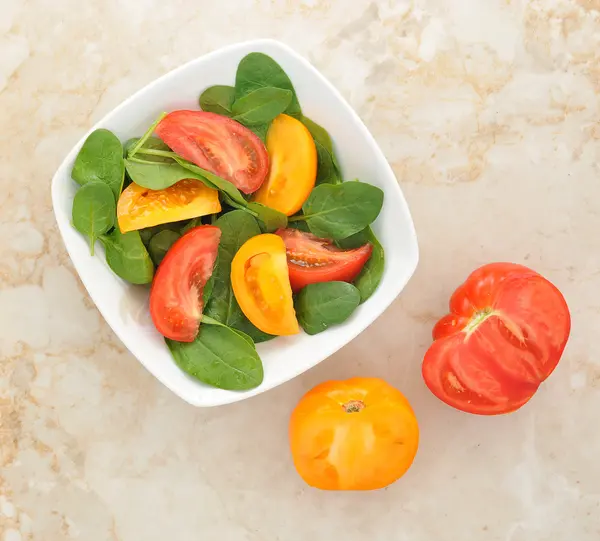 Салат с желтыми и красными помидорами и шпинатом — стоковое фото
