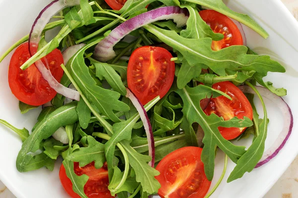 Овощной салат - помидоры черри, аругула, красный лук — стоковое фото