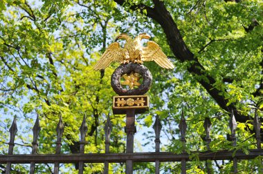 Golden eagle on the fence of the Anichkov garden clipart