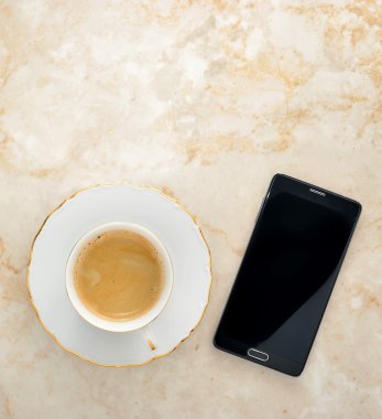 Kahve süt ve mermer bir zemin üzerinde bir telefon