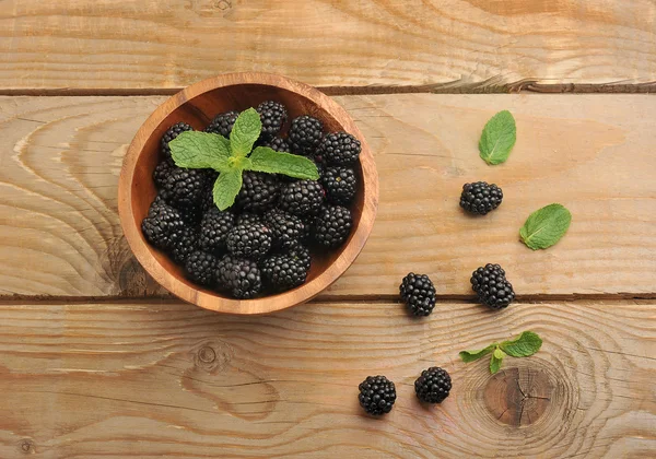 Björnbär i en träskål med mynta blad — Stockfoto