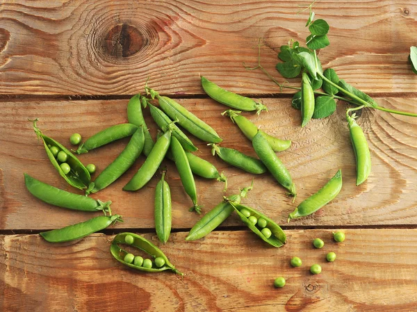 Jonge erwten op een houten achtergrond — Stockfoto