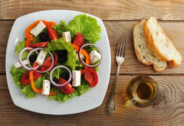 Salade met feta kaas, zwarte olijven met basilicum blaadjes en UI — Stockfoto