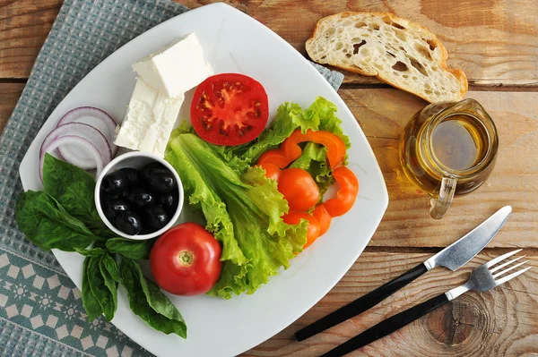 Salade met feta kaas, zwarte olijven met basilicum blaadjes en UI — Stockfoto