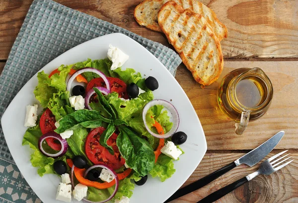 Salade met feta kaas, olijven, tomaten en sla en basilicum o — Stockfoto