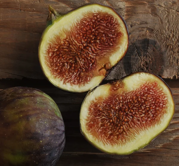 Ripe figs - two slices of figs on wooden background in rustic st — Stock Photo, Image