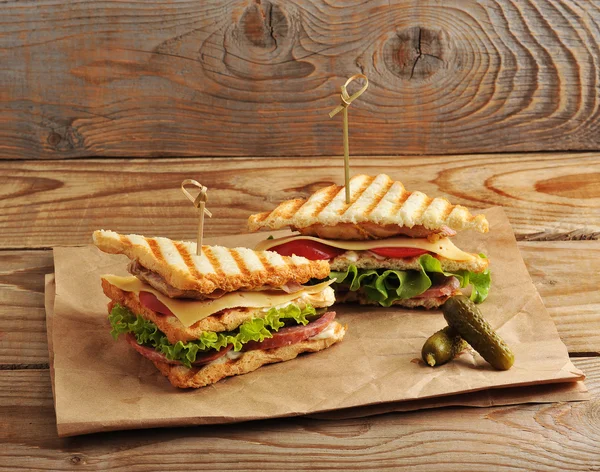 Dos encurtidos sándwich en papel kraft sobre fondo de madera — Foto de Stock