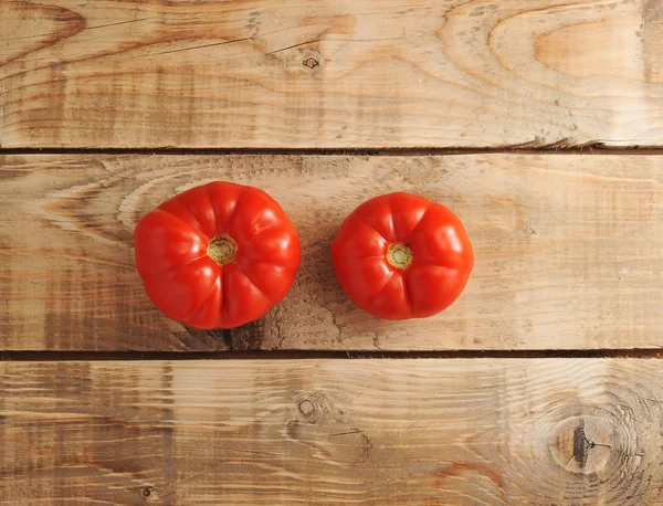 Twee rode tomaten op rustieke houten achtergrond — Stockfoto