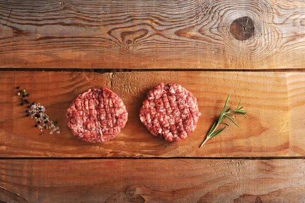 Dos albóndigas picadas de carne cruda sobre fondo rústico de madera — Foto de Stock