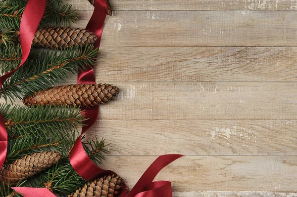 Boże Narodzenie Tło Choinkami Szyszki Czerwoną Wstążką Drewnianym Tle Widok — Zdjęcie stockowe