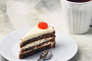 Beyaz fincanda çay, gri arka planda havuçlu kek