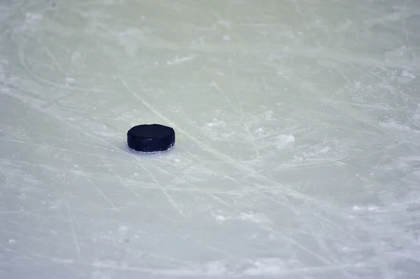 Puck de hockey negro en pista de hielo — Foto de Stock