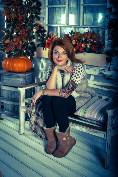 Chica sentada en el banco en la atmósfera de otoño y la calabaza —  Fotos de Stock