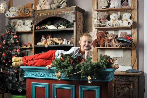 Christmas boy around the Christmas tree with gifts and toys Tedd — Stock Photo, Image