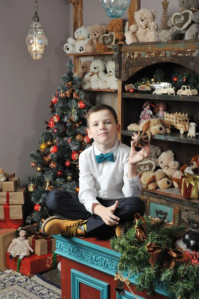 Jul dreng og Nøddeknækker omkring juletræ med gave - Stock-foto
