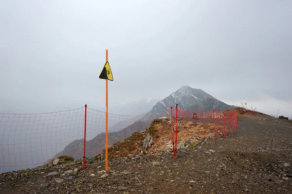 Ondertekenen van gevaar voor het vallen van een hoogte op de top van de berg roos — Stockfoto