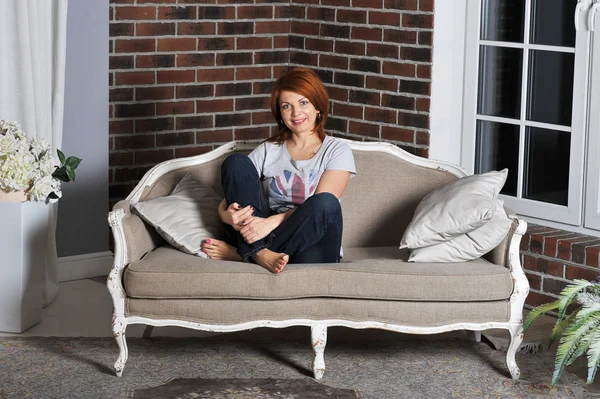 Flicka sittande på soffan — Stockfoto