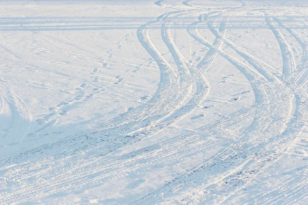Abstrakt bakgrund spår av däck på snö — Stockfoto