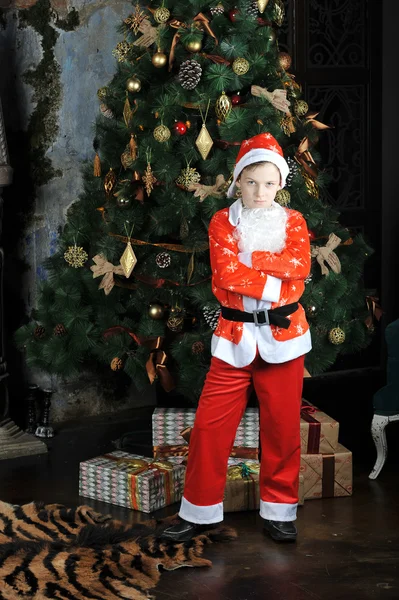 Niño pequeño en traje de Santa Claus de pie alrededor de la Navidad t — Foto de Stock